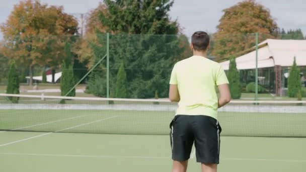 Vista Posterior Jugador Tenis Golpea Pelota Con Una Raqueta Joven — Vídeos de Stock