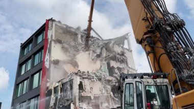 Polonya, Wroclaw - 17 Nisan 2023: Konut alanındaki bir binanın yıkılması, endüstriyel ekipmanların yardımıyla molozların sökülmesi.