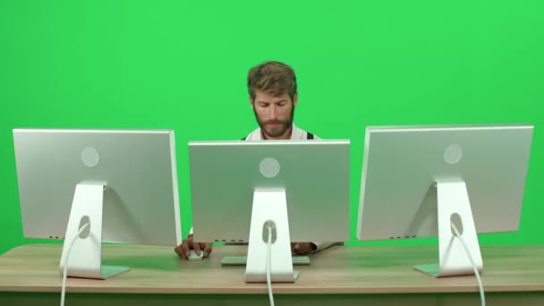 在个人电脑上工作的软件开发人员坐在办公桌前 绿色背景 一个在监视器后面工作的人 色键模板 — 图库视频影像