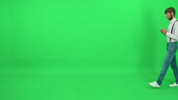 Прохожий Белой Рубашке Ходит Зеленом Фоне Использует Смартфон Шаблон Хромаке — стоковое видео