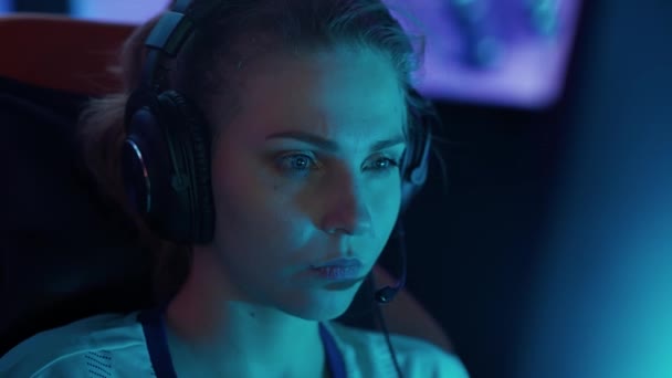 ヘッドフォンで若い女性ゲーマーの肖像画 ゲームでビデオゲーム サイバースポーツマン 選手間のコミュニケーション トーナメント — ストック動画