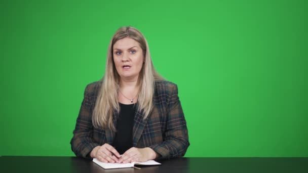 Žena Obleku Podívá Kamery Mluví Zeleném Pozadí Blogger Sedí Stolu — Stock video