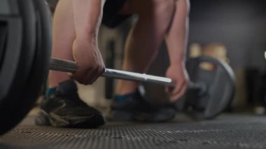 El bilgisayarı, anonim atletik adam halter kaldırmaya hazırlanıyor. Spor salonunda ağırlık çalışması, düşük açılı bakış açısı..