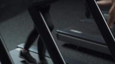 Sağlık, sportif kadın ve erkek koşu bandında koşar, iki koşucu spor salonunda aerobik egzersiz ve dayanıklılık eğitimi yapar, gece hayatı.