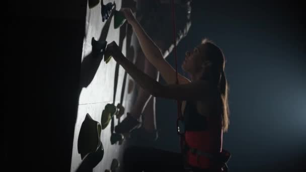 电影照明 专业攀登者在陡峭的墙壁上训练 练习攀岩和爬升 使用保险 4K慢动作 — 图库视频影像