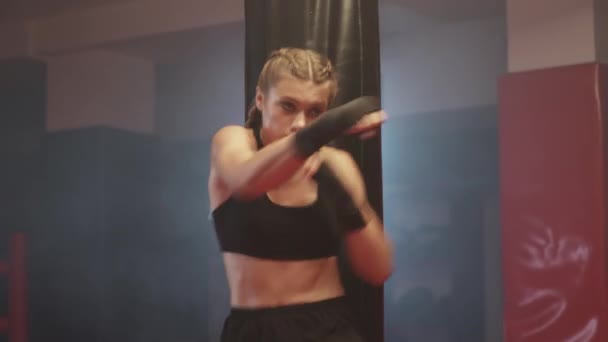 女性戦闘機は ボクシングジムで彼のパンチと防衛を訓練します 女性の列車一連のパンチ 戦闘スタンス — ストック動画