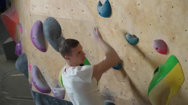 登山の壁で若い男のクライマーのトレーニング ロッククライミングの練習 上からの眺め — ストック動画