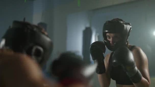 保護ヘルメットを着用した2人の女性戦闘機の戦闘スパイリング ボクシングジムでのトレーニング 女性の列車の防衛 戦闘での一連のパンチ — ストック動画