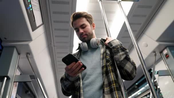 年轻人乘地铁 用智能手机上网 一个学生在大学上学 早上坐公交 — 图库视频影像
