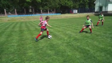 Bir grup genç erkek futbol oynuyor, futbol sahasında antrenman yapıyor, gençler yaz günü futbol oynuyor, çocuklar gol atıyor..