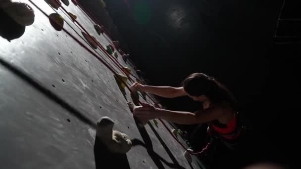 女职业攀登者在攀岩墙上接受训练 练习攀岩和爬升 耐力训练 从高处观看 — 图库视频影像
