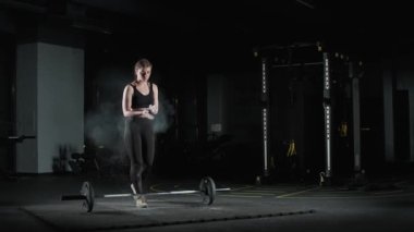 Kadın boksör halterle kaldırma hareketi yapıyor, halteri kaldırıyor ve ağırlık çalışması yapıyor, kadın gücü..