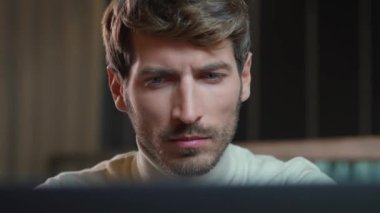 Dizüstü bilgisayarda çalışan genç bir tasarımcının portresi odaklanmış adam kameraya bakıyor, düşünme süreci.