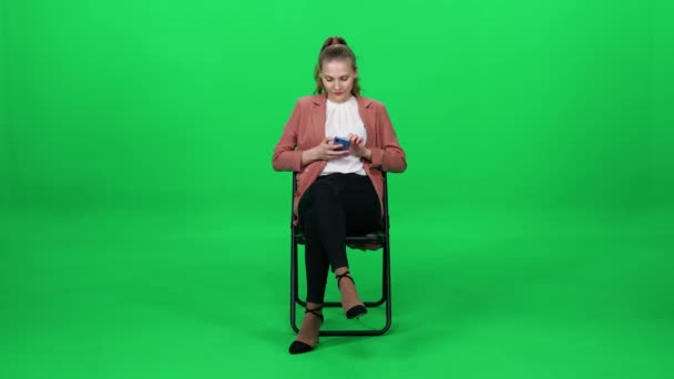Elegantní Běloška Kabátě Sedící Kancelářské Židli Používající Smartphone Zelené Pozadí — Stock video