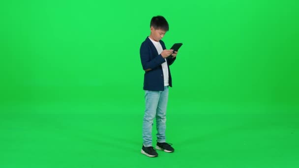 Aziatisch Schooljongen Een Pak Staan Een Groene Achtergrond Met Behulp — Stockvideo