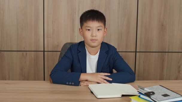 距離学習 リビングルームの机に座ってアジアの学校のボーイは オンラインで自宅で勉強 ビデオ通話でオンラインホームスクーリング — ストック動画
