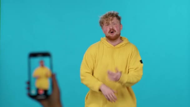Jovem Capuz Amarelo Dança Com Música Fundo Azul Faz Vídeo — Vídeo de Stock