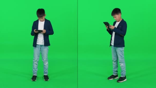 緑の背景に立ってスクリーンタブレットを使用してスーツに焦点を当てたアジアの学校のボーイは 染色体の電子ブック ビデオコラージュテンプレートを読みます — ストック動画