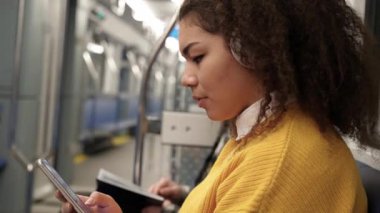 Genç öğrenci metroya biniyor, koyu tenli kadın kulaklıkla müzik dinliyor, akıllı telefon kullanıyor, internette sörf yapıyor, toplu taşıma araçları kullanıyor..