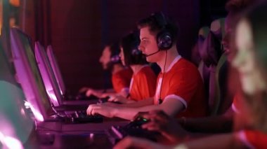 Odaklanmış oyuncular bir video oyunu oynuyor, siber sporcular uluslararası şampiyonada oynuyor, kırmızı takım oyuna başlıyor, neon ışıklı..