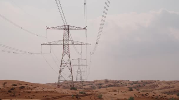 パワーライン 砂漠の電気伝送ラインの産業ビュー ワイヤーが付いている鋼鉄タワーおよび田舎の電力供給のコミュニケーション — ストック動画