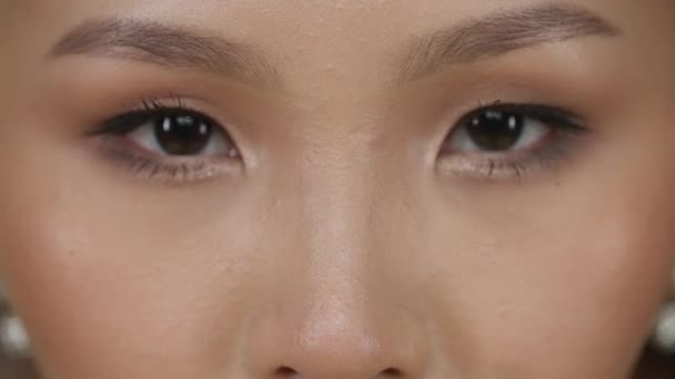 美しいアジアの女性の肖像画 若い女性はカメラを見て 目のクローズアップビュー 顔の特徴 — ストック動画