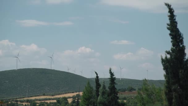 山の近くの丘陵地帯の風力発電所 回転翼 代替再生可能エネルギー源 風力タービンの眺め — ストック動画