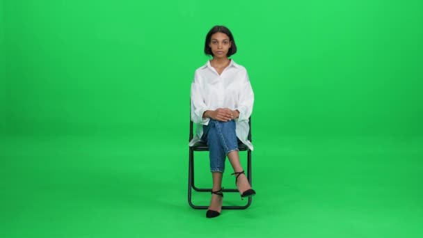 Donna Dalla Pelle Piuttosto Scura Con Una Camicia Bianca Seduta — Video Stock