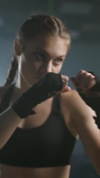 女战士的战斗姿态 训练他的拳 在拳击馆训练 女子快速训练一系列拳 女子力量 垂直录像 — 图库视频影像