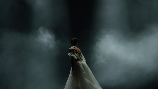 芭蕾舞表演 戏剧性的舞蹈 穿着白色礼服的优雅的芭蕾舞演员 芭蕾舞演员在黑色背景下表演舞蹈元素 在黑暗舞台上的朦胧效果 4K超级慢动作 — 图库视频影像
