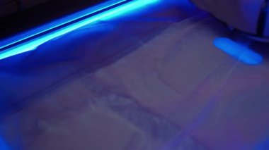 Kulaklıklı genç ve güzel bir kadın duyusal yoksunluk odasına uzanıyor, mavi neon ışığı, kaplıcada dinlenme, meditasyon..