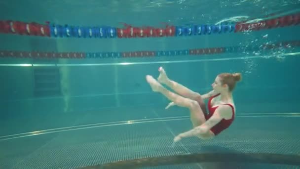 专业的女游泳选手在游泳池里 年轻女子表演着花样游泳的元素 在水下跳着美丽的舞蹈 — 图库视频影像