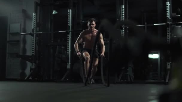 Atletik Adam Dövüş Halatlarıyla Spor Salonunda Dayanıklılık Eğitimiyle Sinema Işığıyla — Stok video