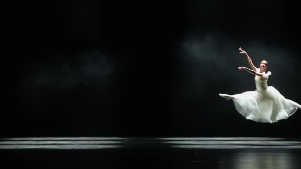 パフォーマンス 白いチュートゥダンスで優雅なバレリーナと黒の背景で劇的な振り付け要素を実行 風と美しいダンス スローモーション — ストック動画