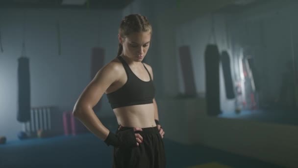 慢镜头 一个女职业拳击手站在拳击馆里 看着镜头 女人的力量 柔和的焦点 4K慢镜头 — 图库视频影像
