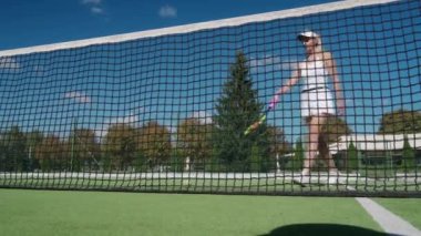 Genç bayan tenisçi bir tenis sahasında topa vuruyor, tenis hilesi, düşük açı, yavaş çekim.