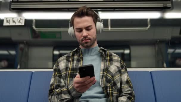Odaklanmış Genç Adam Metroya Biniyor Kablosuz Kulaklıkla Müzik Dinliyor Akıllı — Stok video