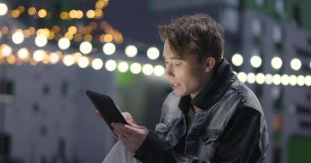 Νεαρός Άνδρας Χρησιμοποιεί Ένα Tablet Και Μιλά Βίντεο Κοντά Στη — Αρχείο Βίντεο