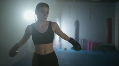 Yorgun bir kadın dövüşçünün portresi, genç bir kadın boks salonundaki sert bir dövüşten sonra iyileşiyor, kadın gücü, 4k ağır çekim.