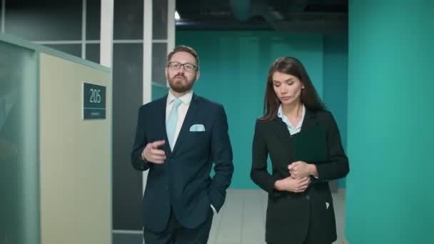 ビジネスミーティング トップマネージャーのカップルは 会議に行きます オフィススペースのインテリア 高層ビル内のオフィスを散歩 フロントビュー — ストック動画