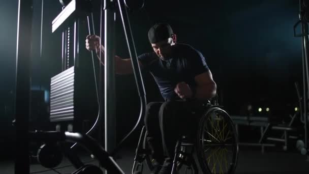 坐轮椅的残疾人运动员在齿轮机上 力量训练在齿轮机上 残疾人 — 图库视频影像