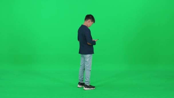 Back View Asian Schoolboy Suit Standing Green Background Talking Mobile — Stock Video