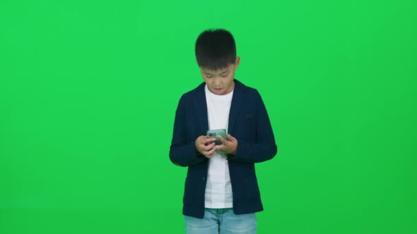 Gry Mobilne Azjatycki Uczeń Garniturze Stojący Zielonym Tle Grający Grę — Wideo stockowe