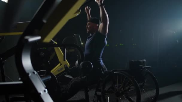 剧烈运动 在健身房的轮椅起重块上的残疾运动员 在滑块装置上的力量训练 残疾人 电影照明 — 图库视频影像