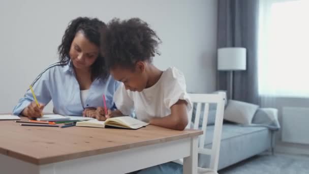 和妈妈一起在家里做作业的 手牵着手的 皮肤黝黑的小女孩 在家学习 — 图库视频影像
