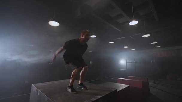 白俄罗斯 明斯克 2021年6月9日 自由奔跑 健美的男子在练习场上做了一系列的筋斗训练 在黑暗的空间中表演体操技巧 — 图库视频影像