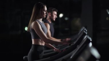 Sağlık, genç kadın ve erkek atlet bir koşu bandında yürür ve koşmaya başlar, iki koşucu spor salonunda aerobik egzersiz ve dayanıklılık eğitimi yapar, gece hayatı.