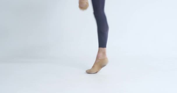 年轻的男子跳芭蕾舞 穿着尖尖的鞋子 两条腿相平衡 背景是白色的 — 图库视频影像