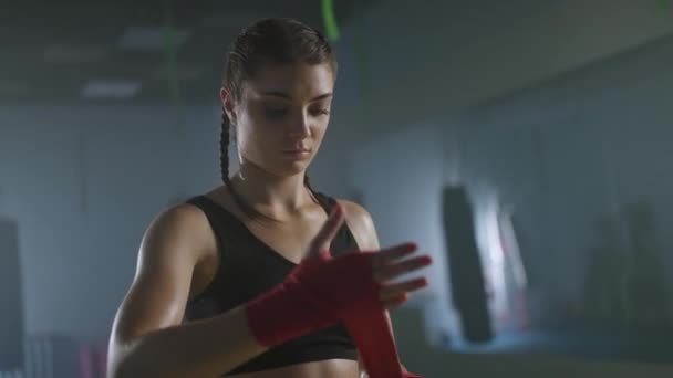 白俄罗斯 明斯克 2021年9月18日 身强体壮的女战士用拳击绷带捂住双手 训练日在体育馆里 漂亮的女战士正在准备战斗 — 图库视频影像