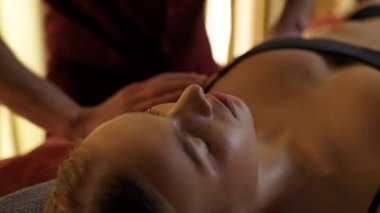 Profesyonel masör genç bir kadına rahatlatıcı bir el masajı yapar..